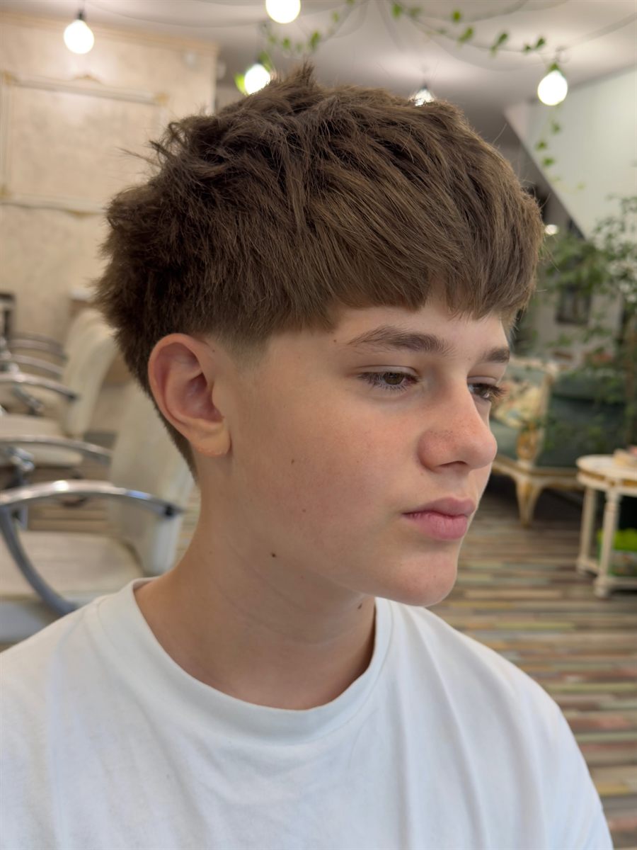 Tunsoare masculină cu taper fade și textură naturală, în salon